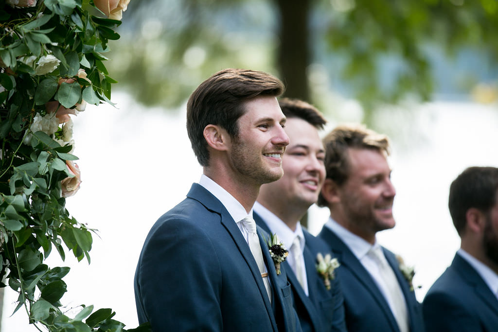 Groom smiling, waiting for bride at ceremony at Six Mile Estate, a Montana wedding venue