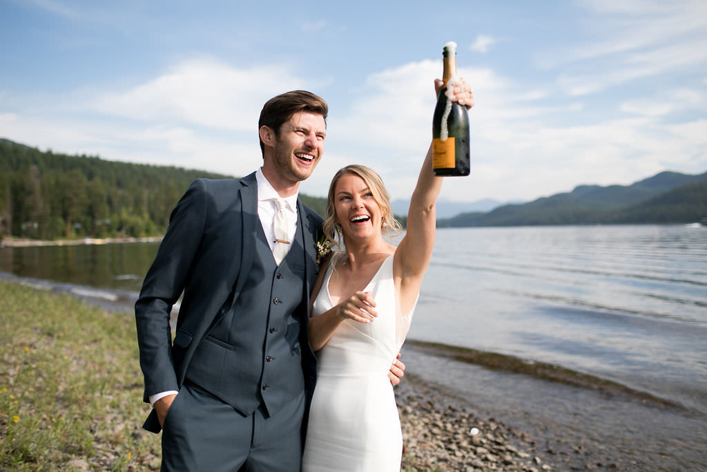 Bride and groom popping champagne on their wedding day at a Montana wedding venue