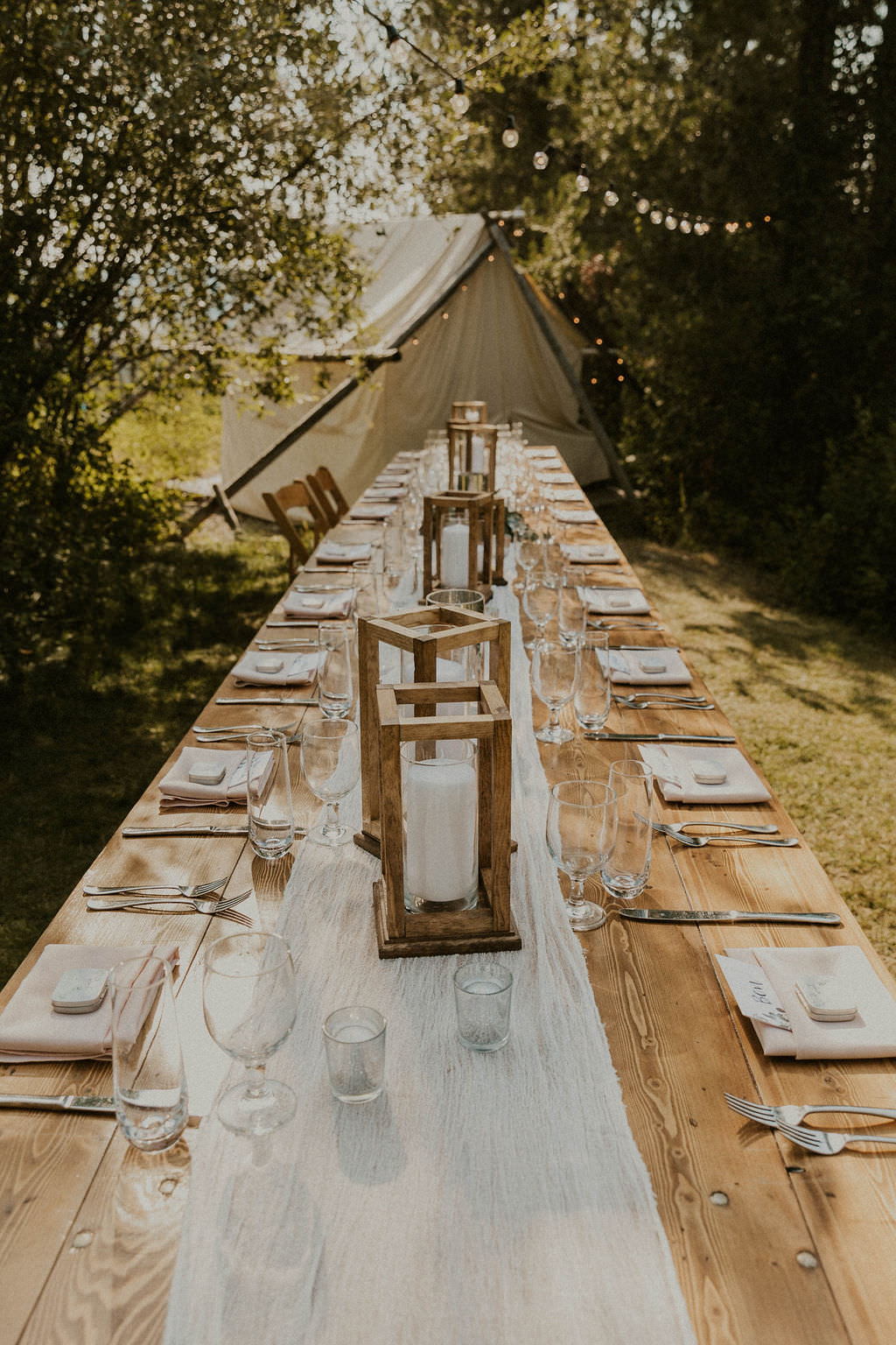 Outdoor wedding table setup using wooden lanterns as simple wedding decor