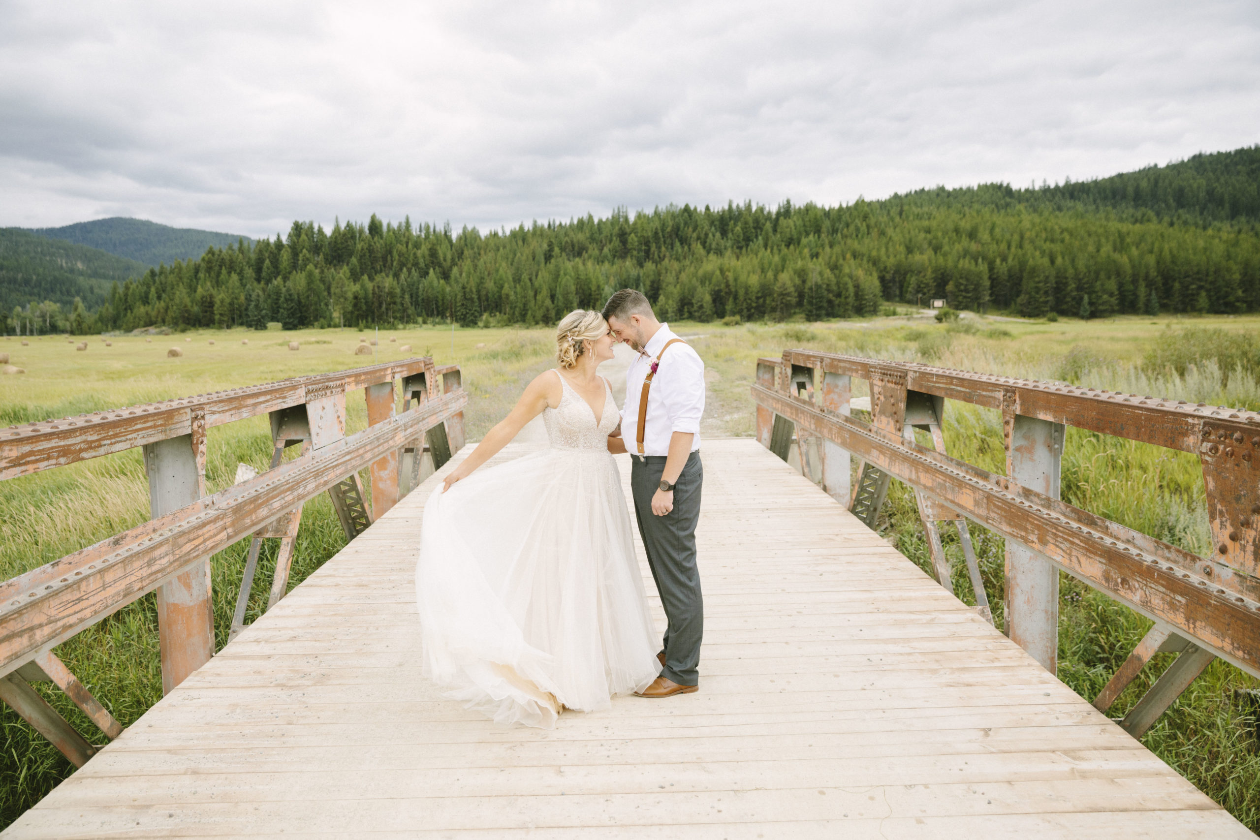 Bride and groom on bridge at ranch wedding